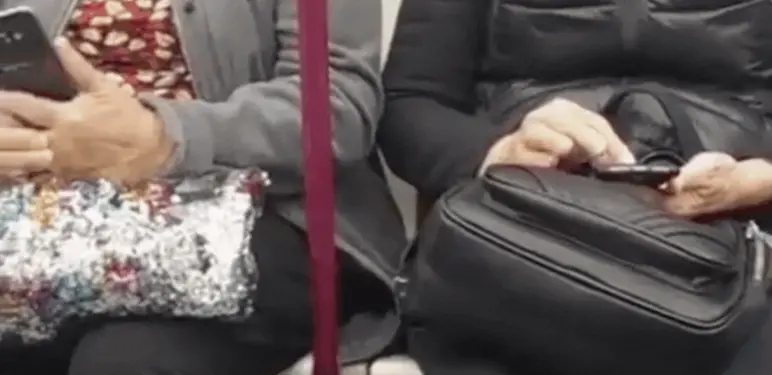 Starije žene u vlaku na mobitelima i mladić koji štrika