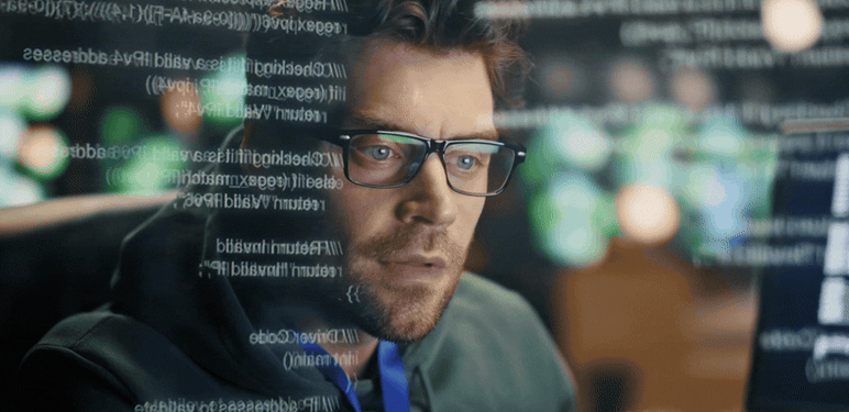 Programer pred računalom i kodovi na ekranu