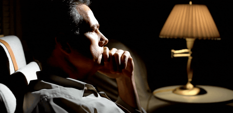 Muškarac koji razmišlja u slabo osvijetljenoj sobi