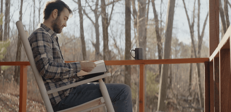 Čitanje knjige na terasi i razmišljanje