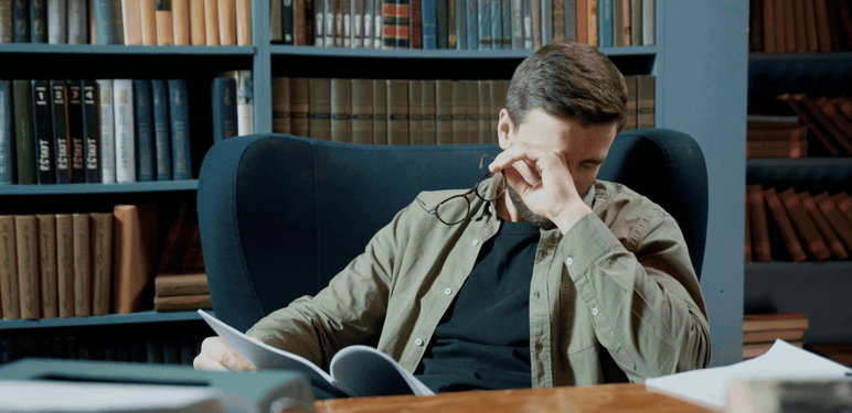 Skidanje naočala u knjižnici i trljanje očiju