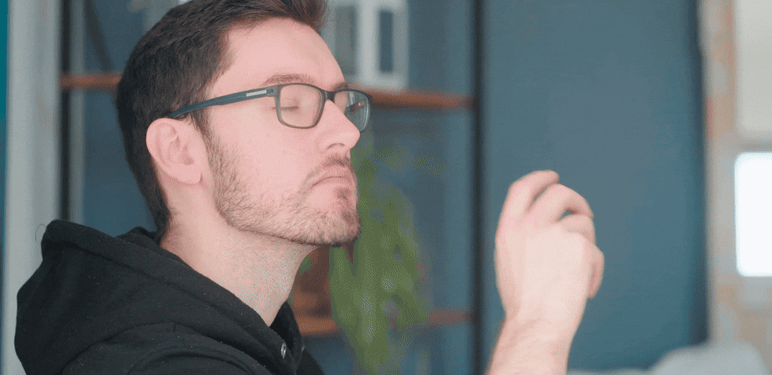 Muškarac s naočalama koji gleda u daljinu i razmišlja