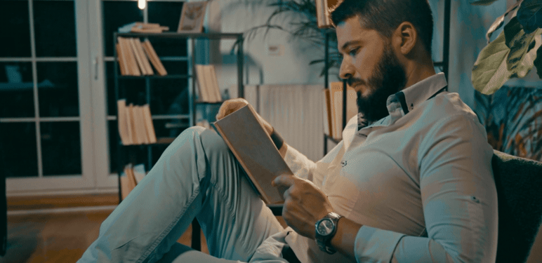 Muškarac na kauču kako čita knjigu