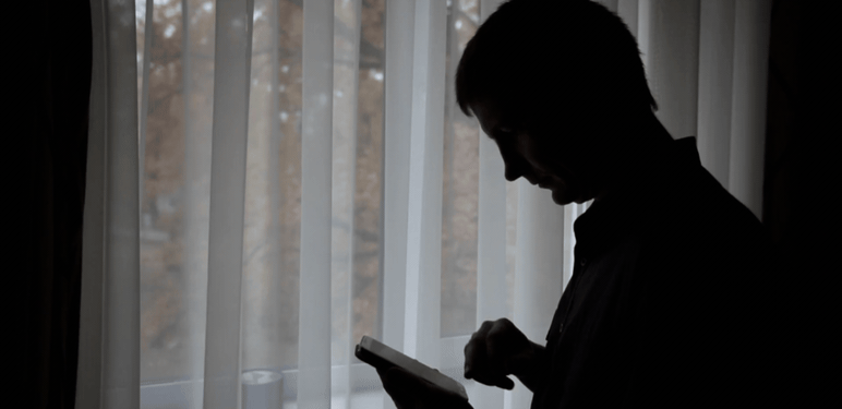 Muškarac koji razmišlja i rješava kviz na mobitelu