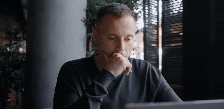 Muškarac koji sjedi za stolom i razmišlja