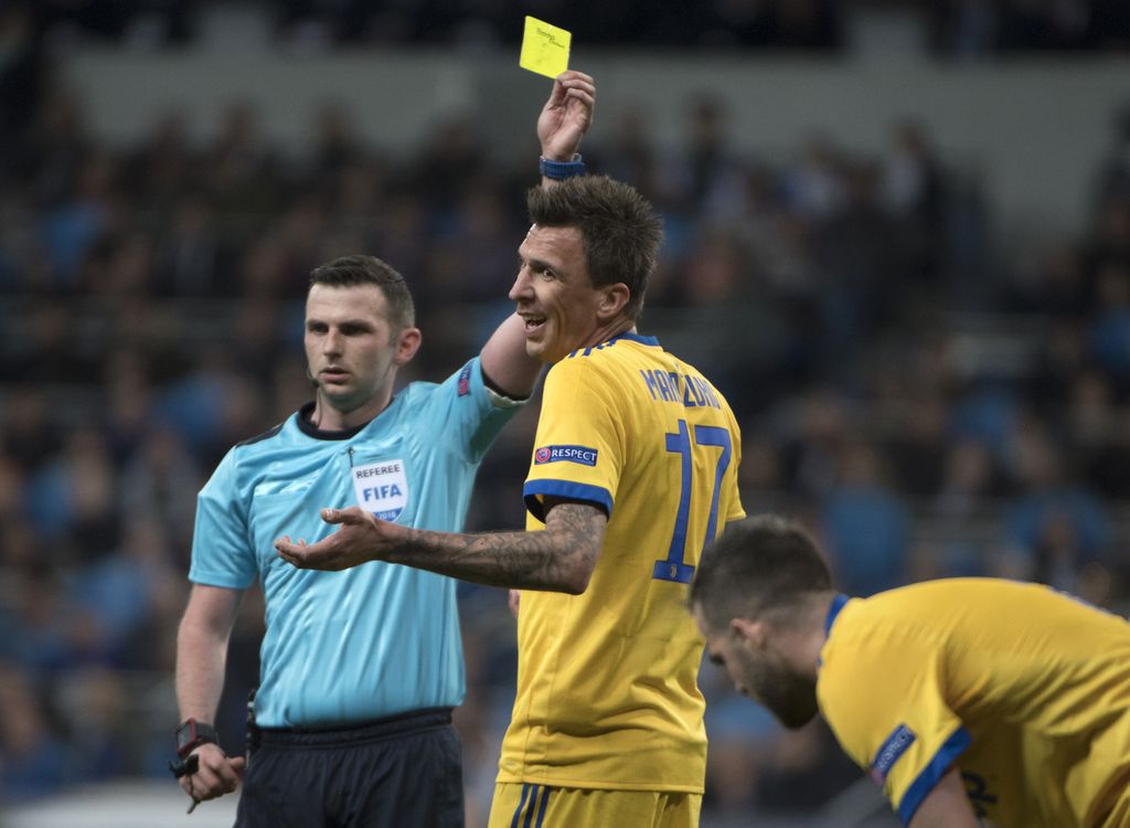 Michael Oliver pokazuje žuti karton Mandžukiću (Foto: AFP)
