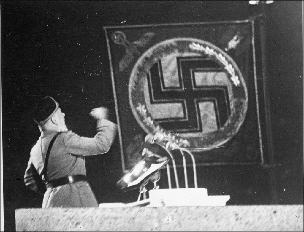 Benito Mussolini pozira uz svoju bistu