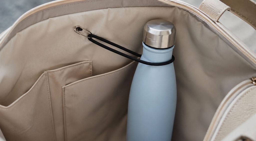 Žena kojoj se prolila voda po torbi