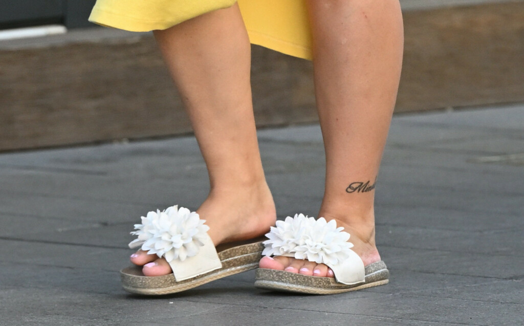 Trudnica iz centra Zagreba nosi bijele ravne natikače s ukrasom u obliku velikog cvijeta