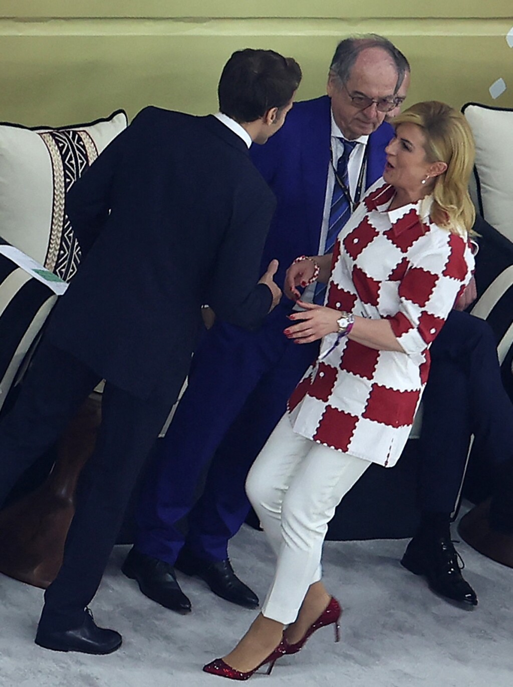Kolinda Grabar-Kitarović u LV košulji, bijelim hlačama i crvenim štiklama sa šljokicama na tribinama