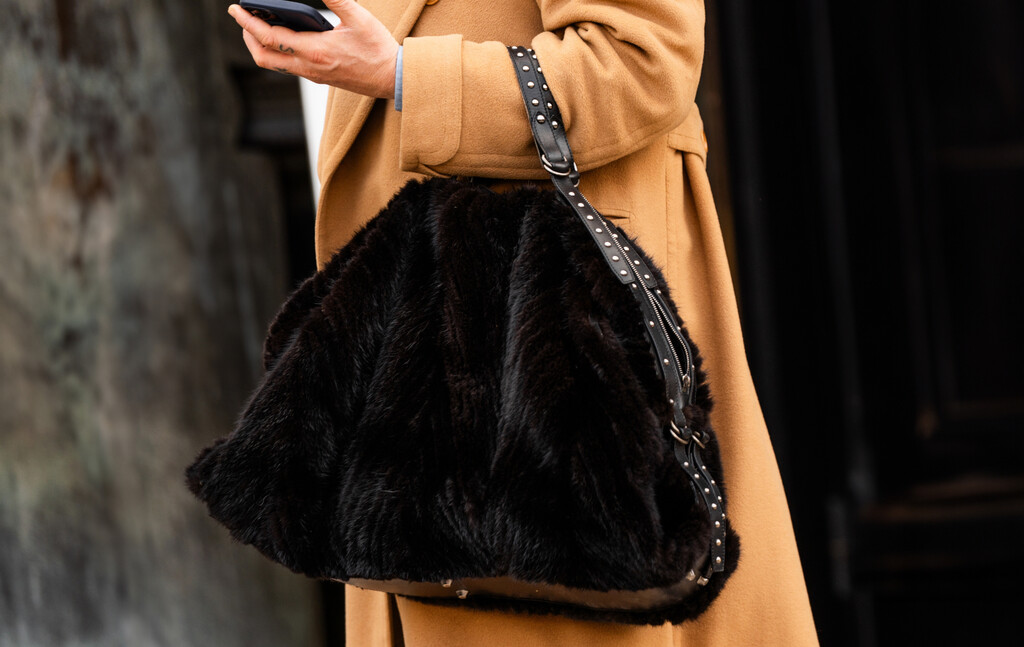 Žena nosi krznenu torbu