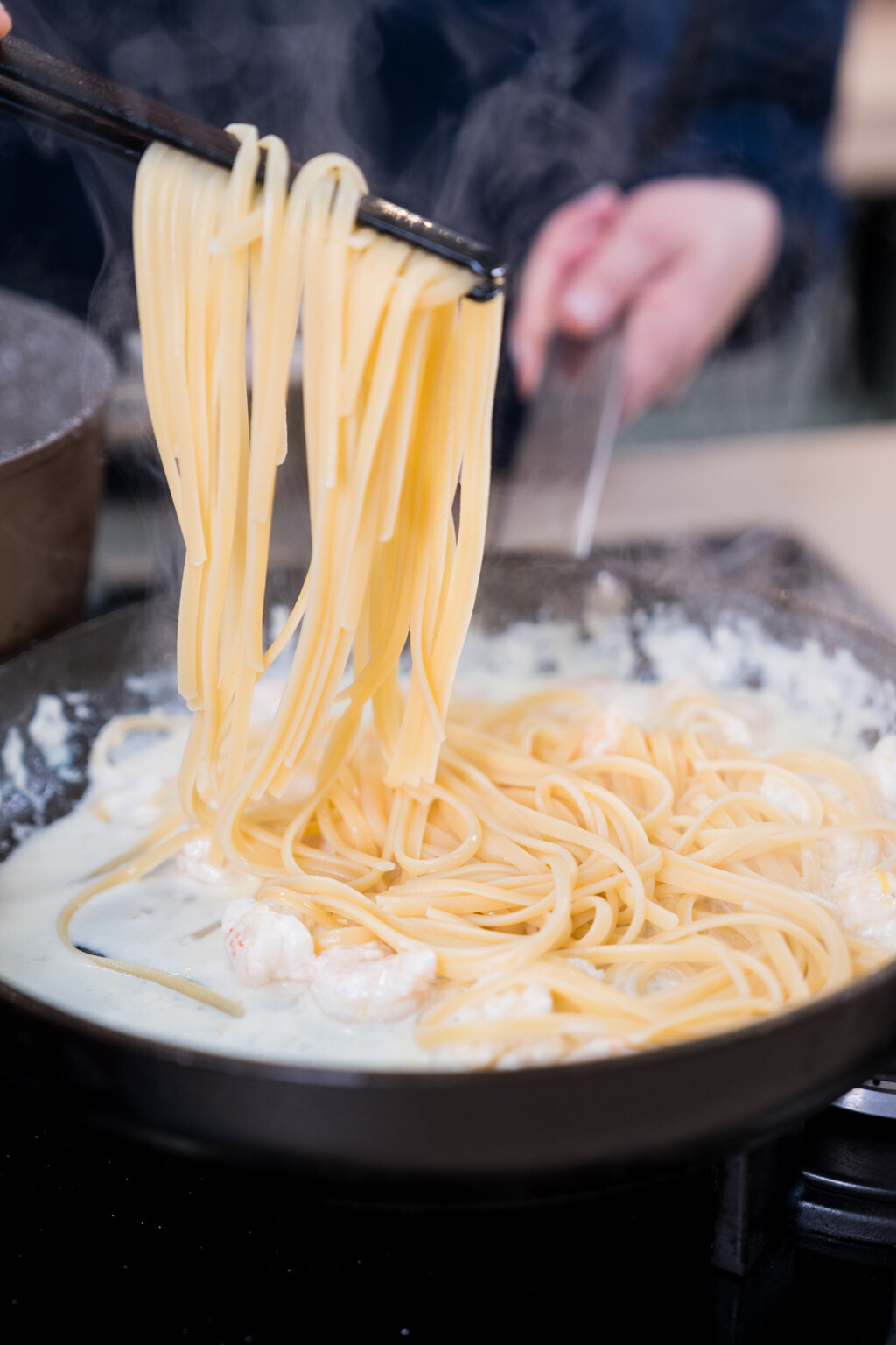 U umak dodajte linguine i malo vode od tjestenine