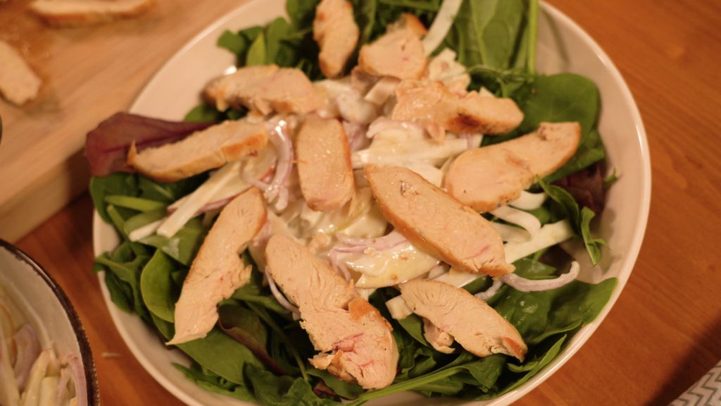 Na sitnu lisnatu salatu stavite waldrofsku salatu i poslažite piletinu narezanu na ploškice