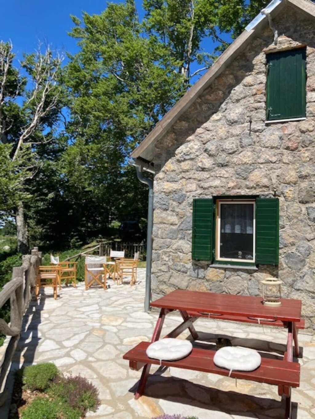 Ispred kuće nalazi se ljetna kuhinja sa stolom i klupama za uživanje na otvorenom