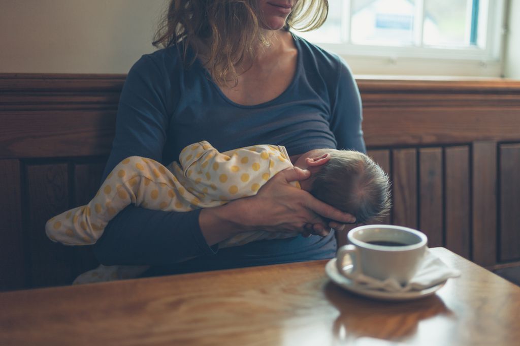 Mlada majka doji dijete u kafiću