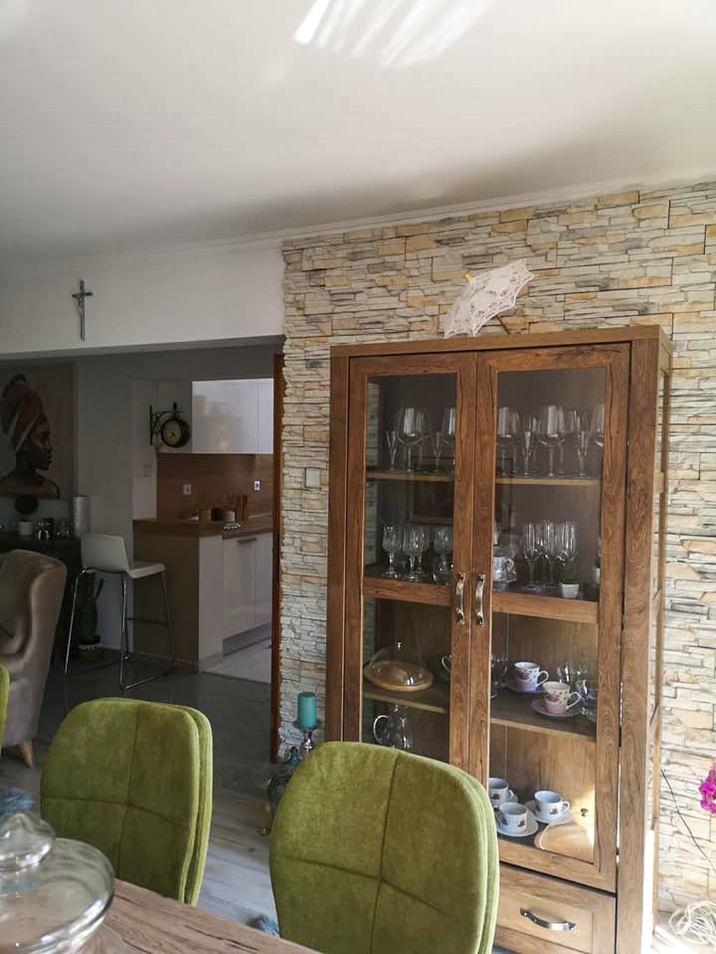 Vitrina od drva i stakla smještena je ispred zida od dekorativnog kamena