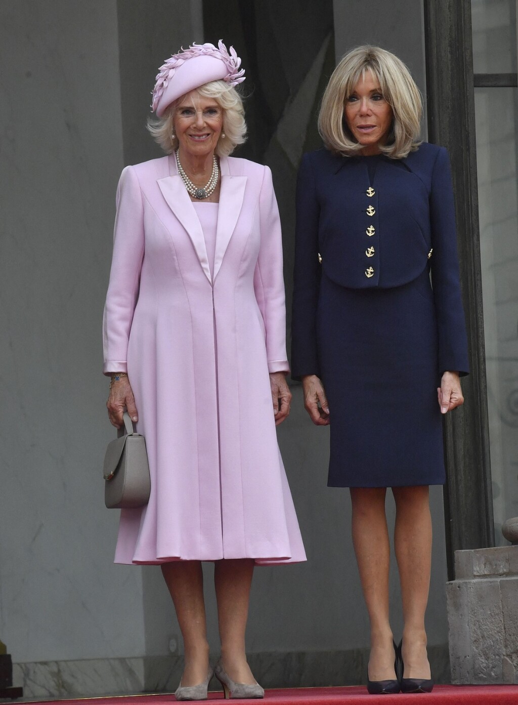 Kraljica Camilla prilikom dolaska u Pariz nosila je ružičasti kaput, a prva dama Francuske plavi kostim