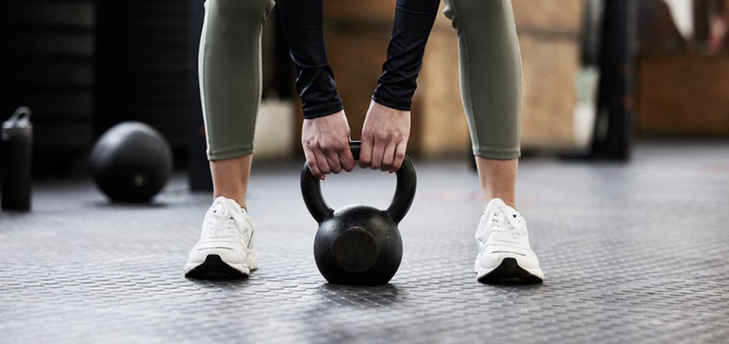 Žena vježba s utegom u teretani