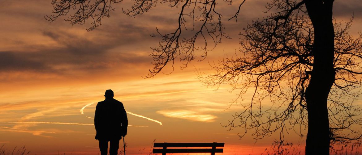Starac usamljeno stoji i gleda zalazak sunca