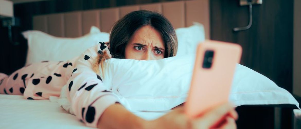 Djevojka zabrinuto gleda u mobitel