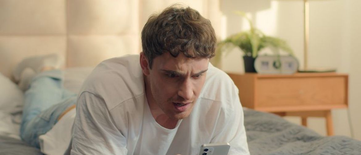 Dečko zabrinuto gleda u mobitel