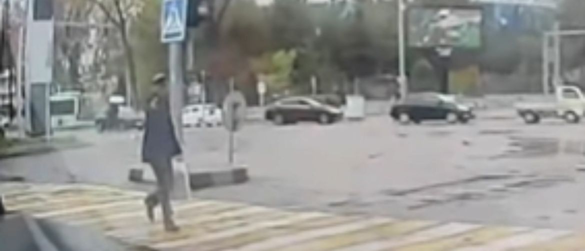 Starac koji prelazi cestu s pištoljem u ruci