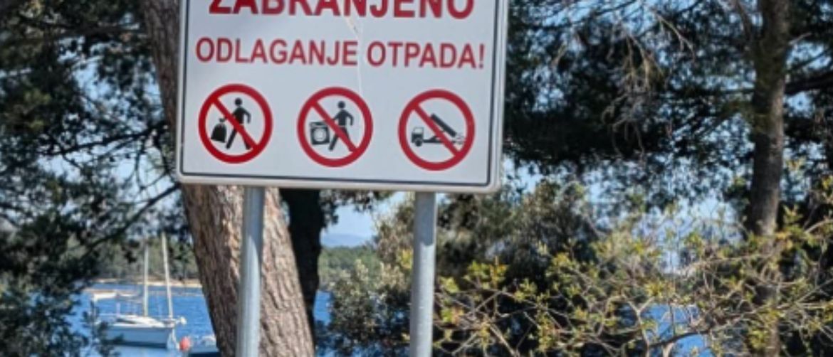 Deponij ispod znaka za zabranu odlaganja otpada