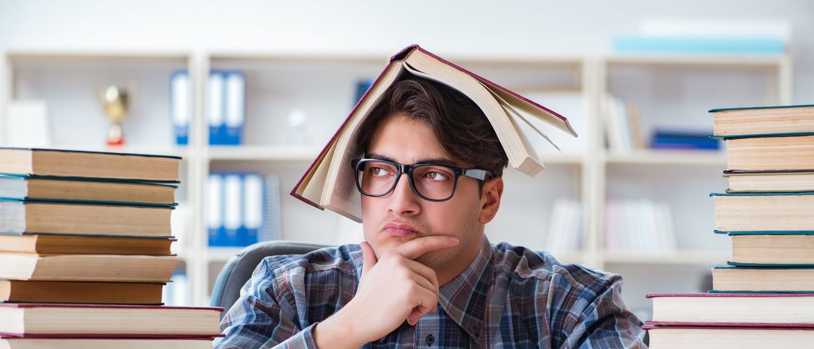 Muškarac među knjigama s jednom na glavi