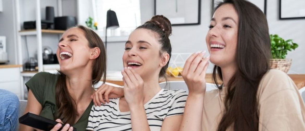 Djevojke se smiju dok gledaju televiziju