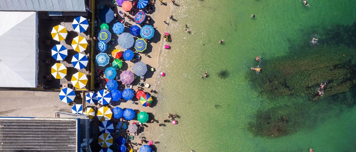 Plaža s kupačima i suncobranima