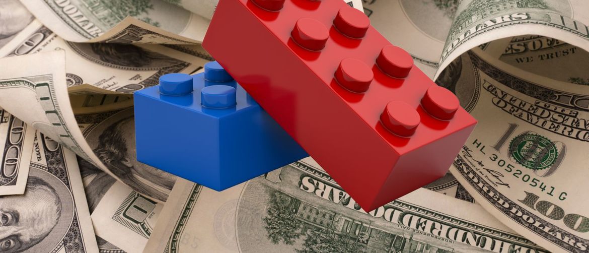 američki dolari pobacani jedan preko drugoga i dvije lego kocke preko njih
