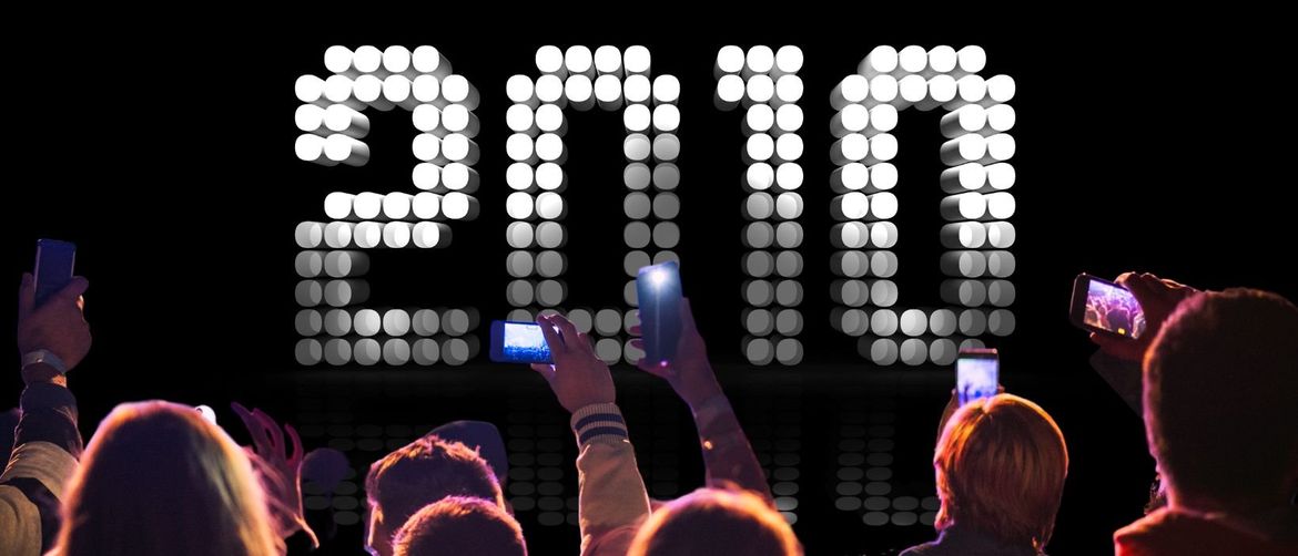 natpis 2010 napisan led panelima i publika koja snima ispred s mobitelima i rukama u zraku kao na koncertu