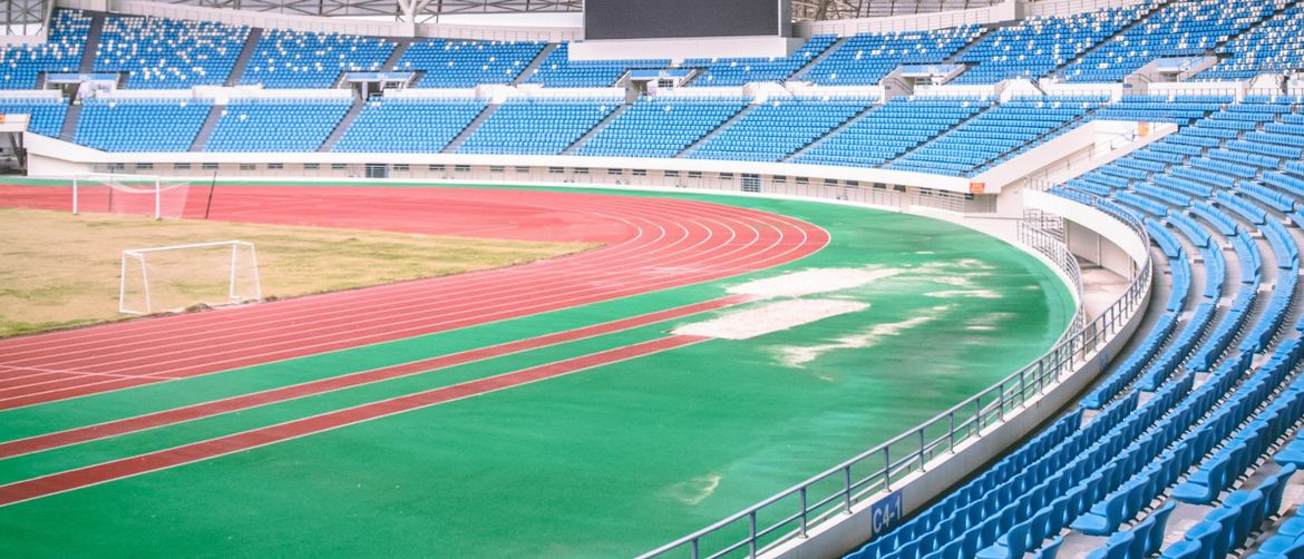 prazan stadion s atletskom stazom travom i golovima