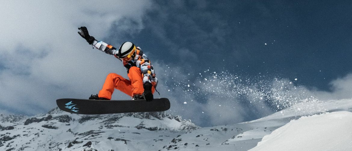 Snowboarder u letu kako izvodi trik