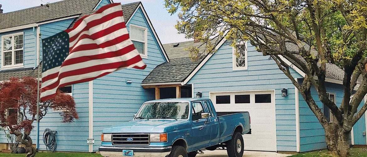 Automobil sparkiran na prilazu ispred kuće i američka zastava koji simboliziraju američki san