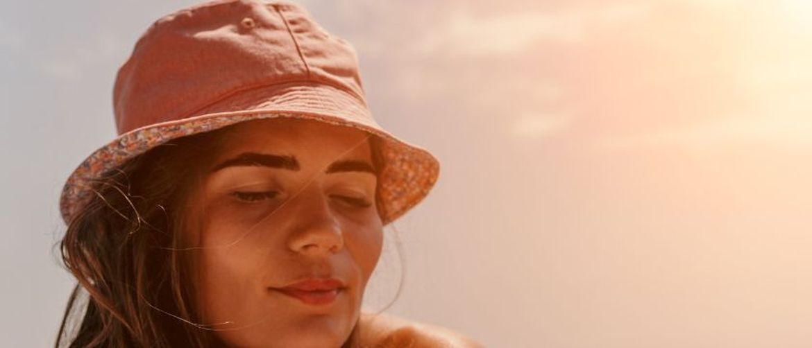 Djevojka sa šeširom se sunča