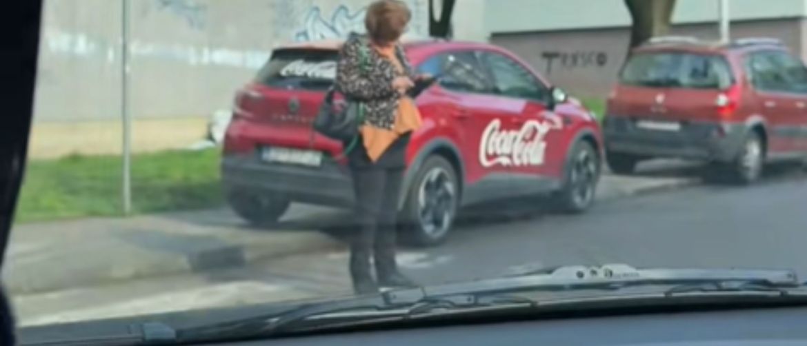 Gospođa na mobitelu nasred pješačkog prijelaza