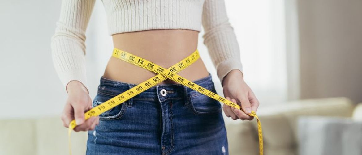 Djevojka drži krojački metar oko struka