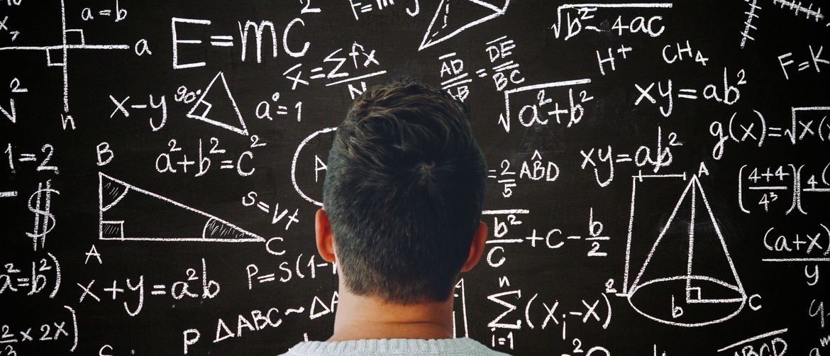 Muškarac kako razmišlja ispred ploče s matematičkim formulama