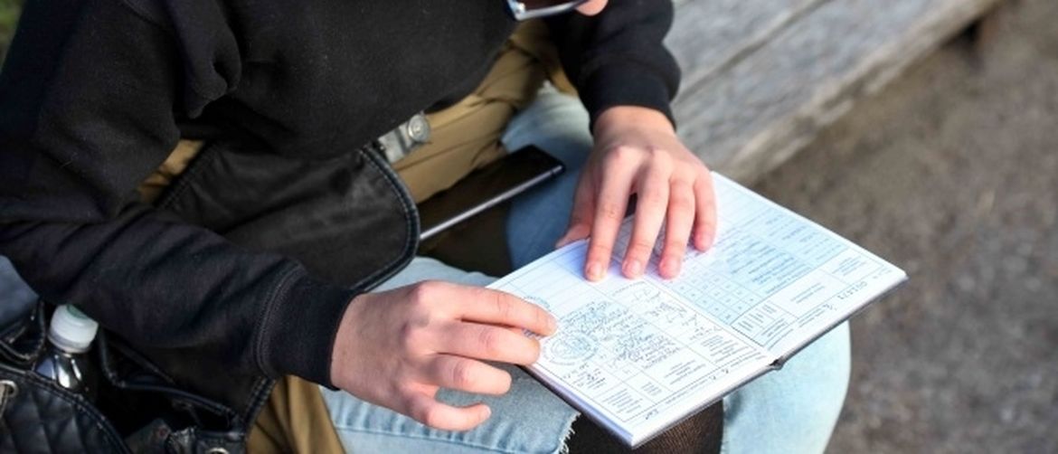 Studentica s indeksom, provjerava ocjene...