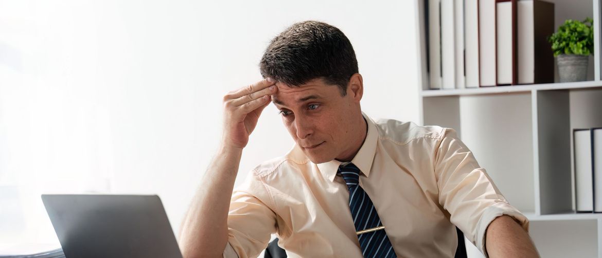 Muškarac kako razmišlja za računalom