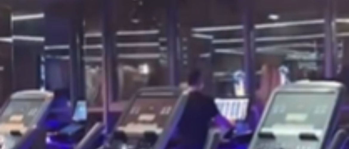 Muškarac u teretani na traci za trčanje