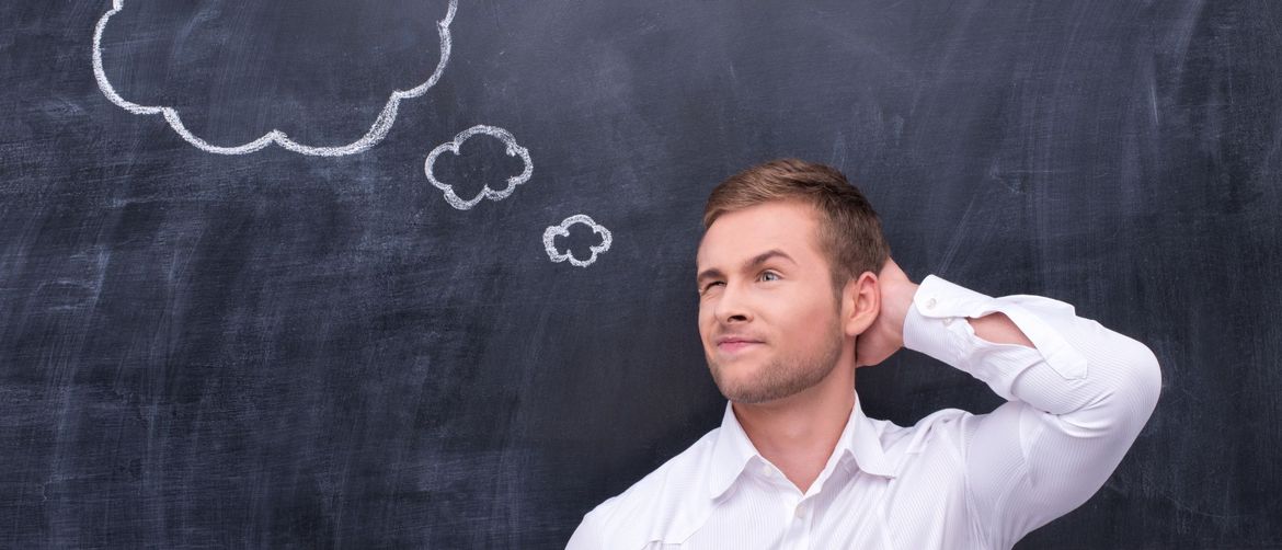 Muškarac koji razmišlja ispred školske ploče