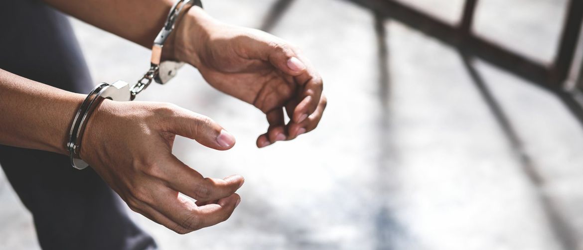 Muškarac s lisicama na rukama u zatvoru