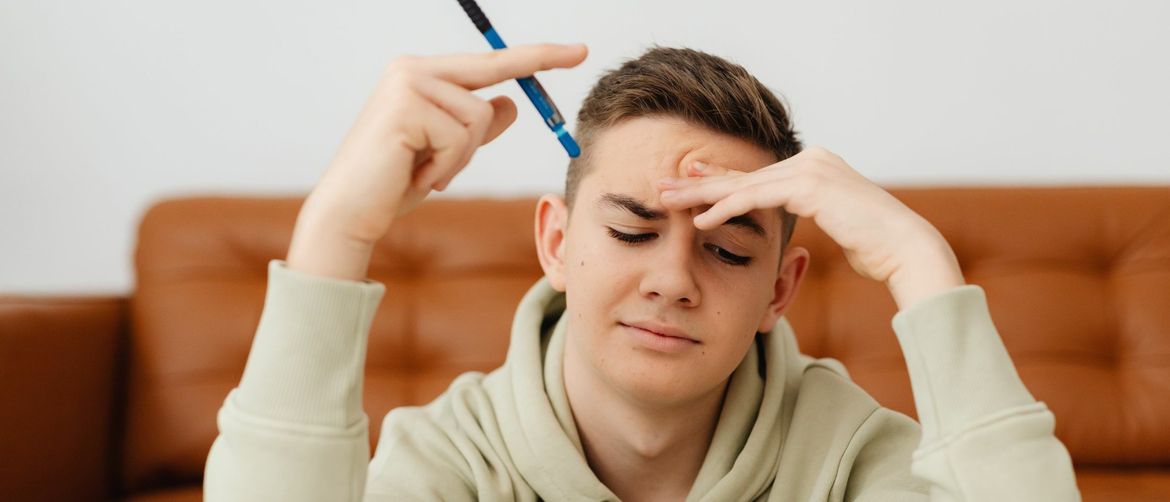 Mladić koji razmišlja s olovkom u ruci