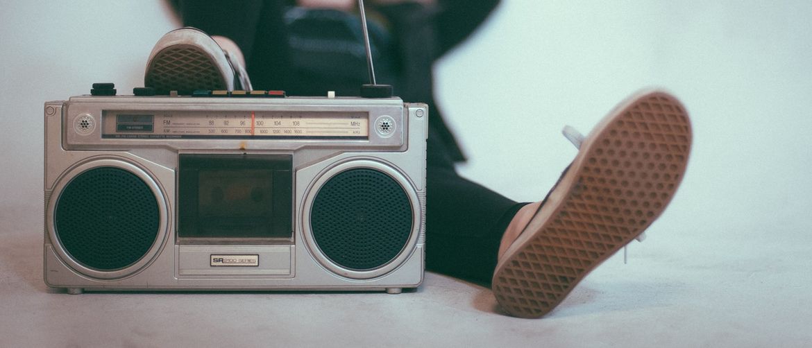 žena leži s nogom na radiju opušteno slušajući glazbu