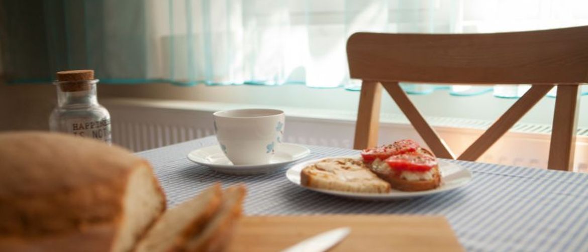 Namaz na kruhu i šalica kave na stolu