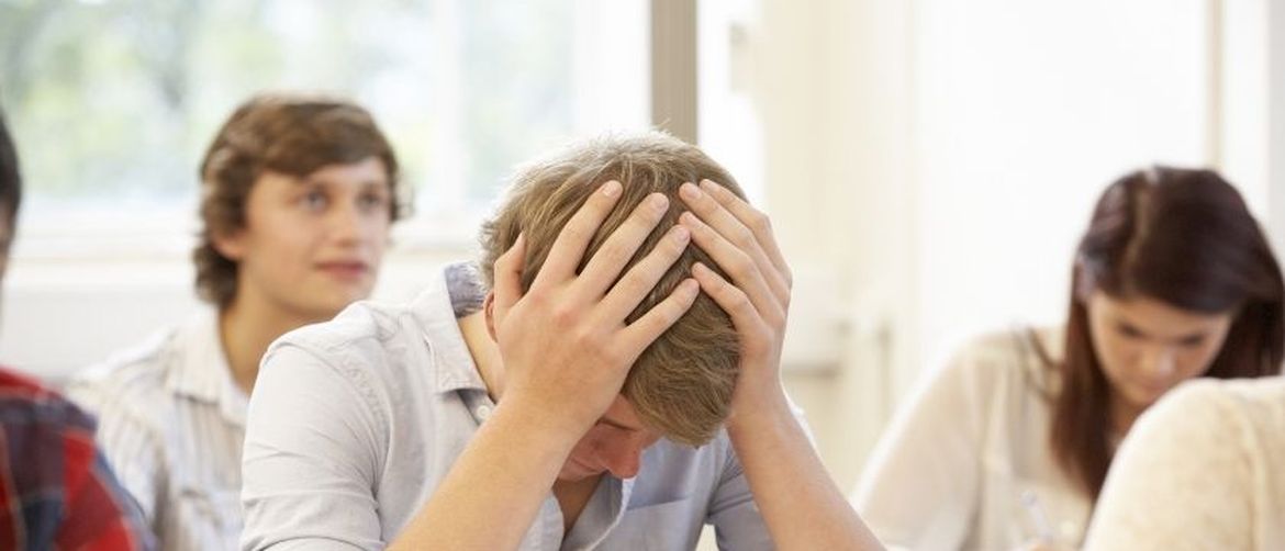 Dečko se drži za glavu