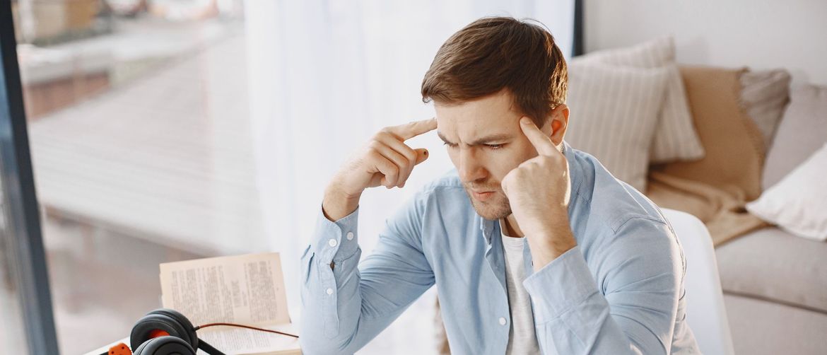 Muškarac za računalom kako razmišlja