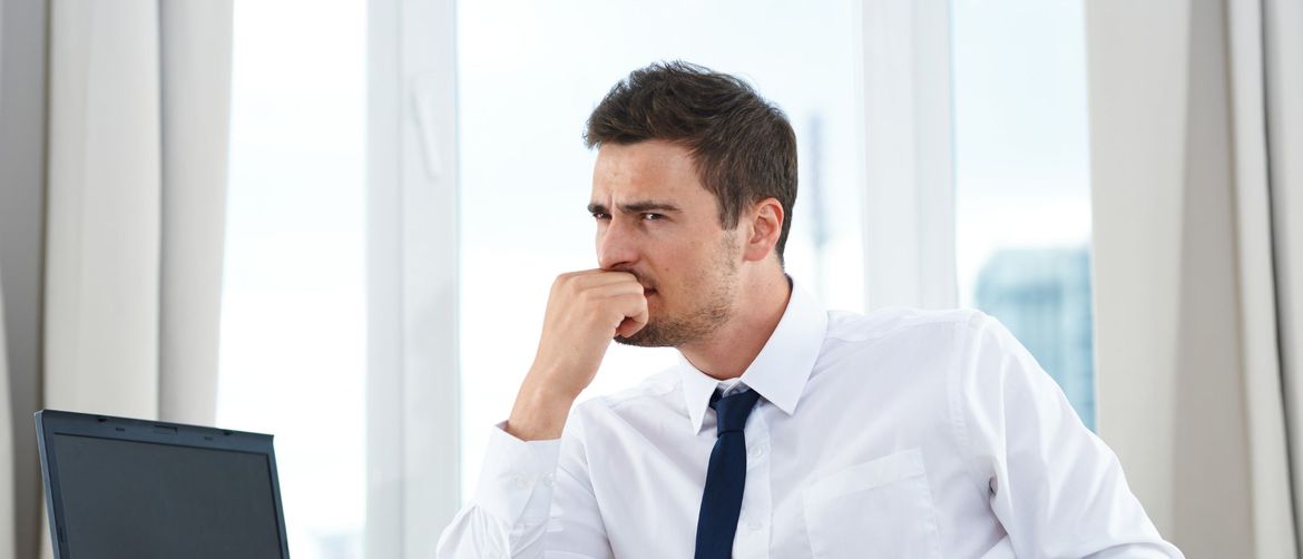 Muškarac koji razmišlja pred računalom